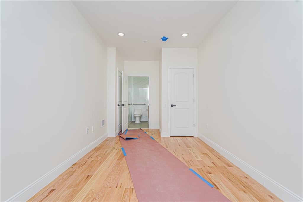 158 Bay 29th Street Brooklyn, NY 11214 - Photo 11 of 24 a view of a room with a bed and wooden floor