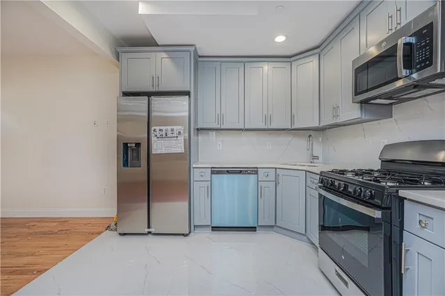 a kitchen with stainless steel appliances granite countertop a stove a refrigerator and a microwave