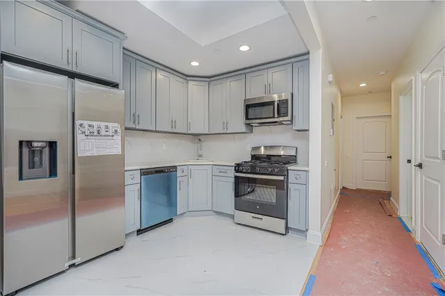 a kitchen with stainless steel appliances granite countertop a refrigerator and a stove