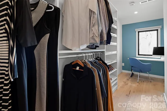 a view of walk in closet with clothes and shoes