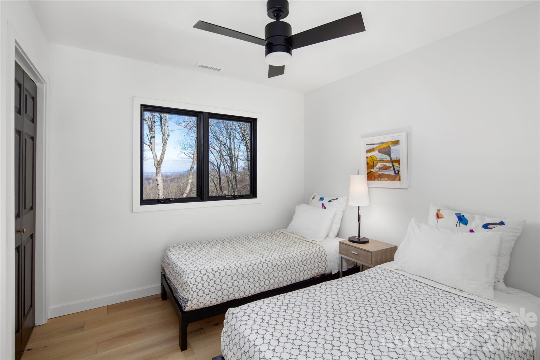 1202 Davis Mountain Road Hendersonville, NC 28739 - Photo 27 of 43 a bedroom with two beds and a chandelier