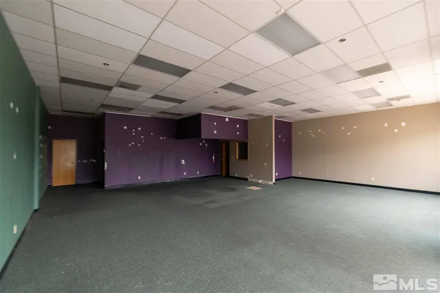 a big room with pool table and windows