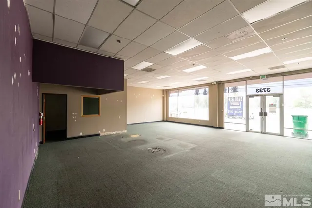 a view of an empty room with a fireplace and a window