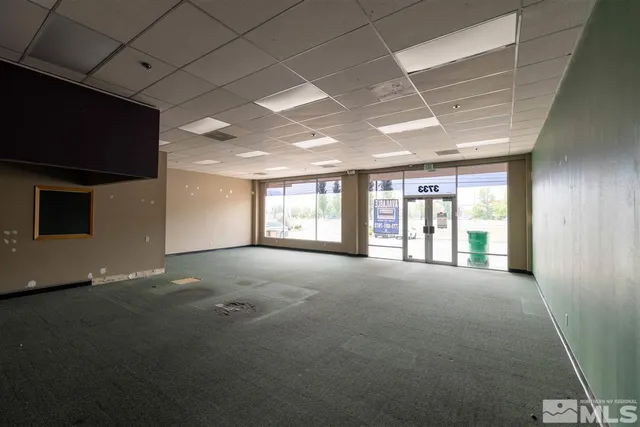 a view of an empty room with a fireplace and a window