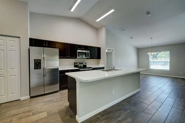 a kitchen with stainless steel appliances a refrigerator sink and microwave