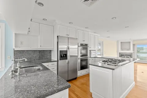 a kitchen with stainless steel appliances granite countertop a sink stove and refrigerator