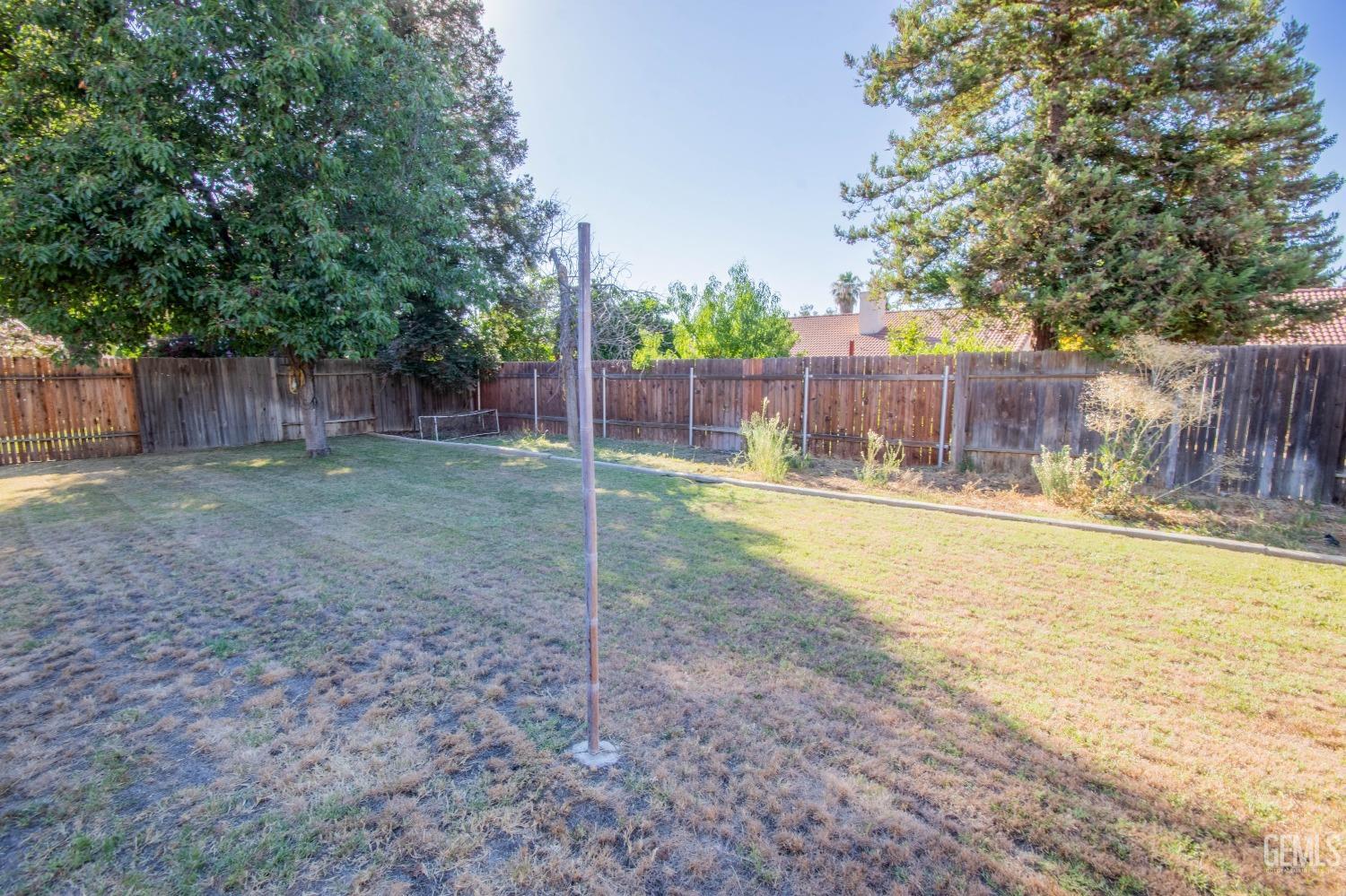 Undisclosed Address Bakersfield, CA 93312 - Photo 9 of 9 a view of a backyard with swimming pool and wooden fence