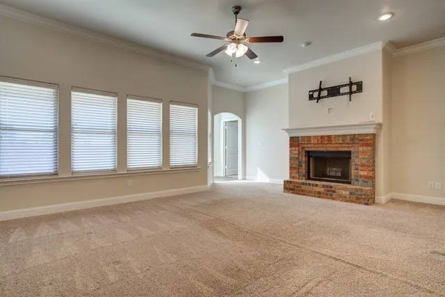 a view of an empty room with a fireplace and a window