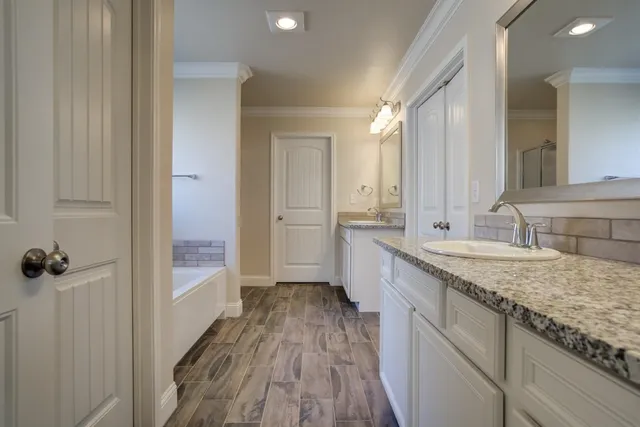 a bathroom with a granite countertop sink a mirror and shower