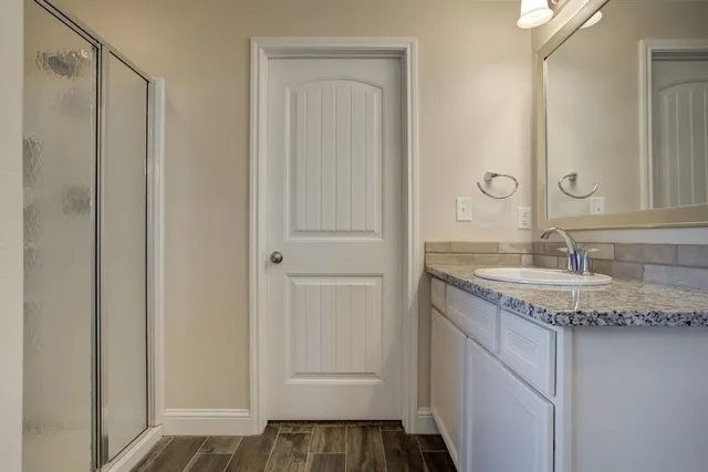 a bathroom with a granite countertop sink and a mirror