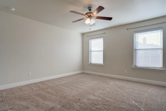 an empty room with a window and a fan