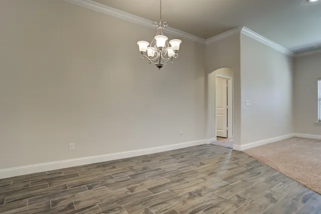 a view of a chandelier fan and hardwood floor