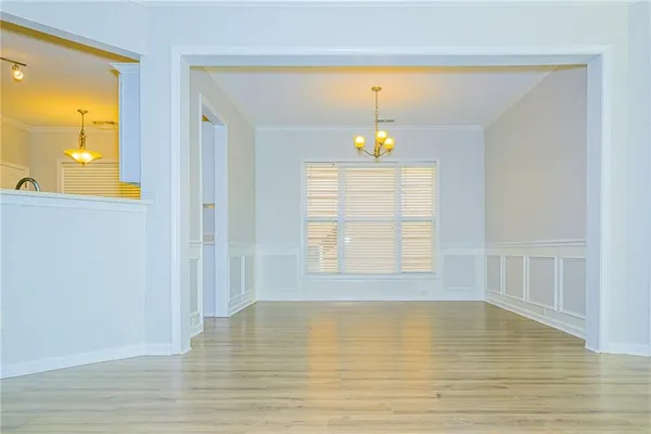 a view of an empty room with window and wooden floor