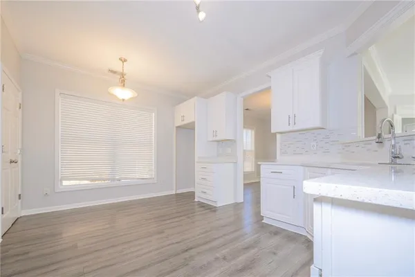 a large kitchen with cabinets wooden floor and stainless steel appliances