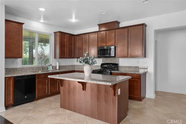 a kitchen with stainless steel appliances granite countertop a sink a stove and a microwave