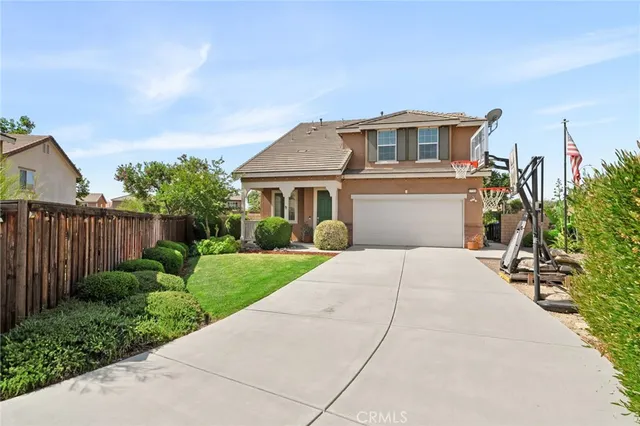 a front view of a house with a yard and potted plants
