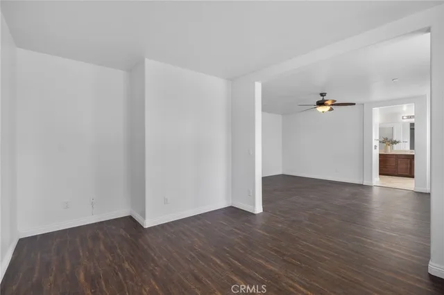 a view of a big room with wooden floor and windows