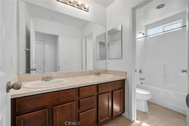 a bathroom with a granite countertop sink a toilet and shower