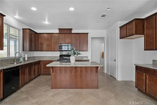 a large kitchen with stainless steel appliances granite countertop a stove a sink dishwasher and a refrigerator