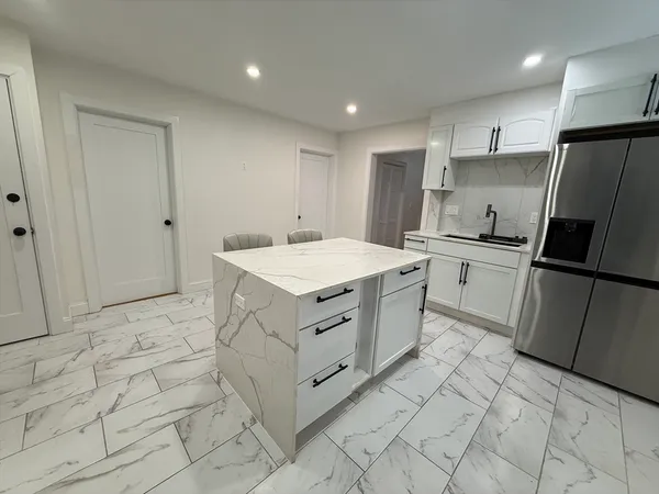 a kitchen with white cabinets appliances and sink
