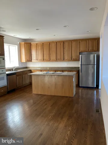 a view of kitchen with granite countertop cabinets and refrigerator