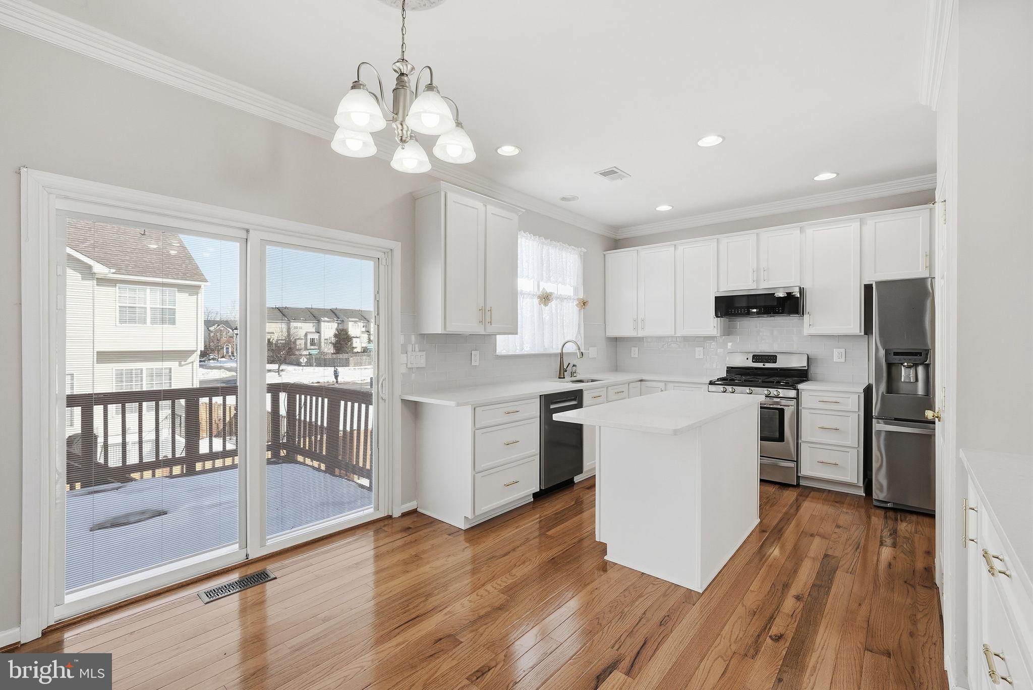 6800 Innesfree Way Gainesville, VA 20155 - Photo 11 of 32 a kitchen with white cabinets and stainless steel appliances