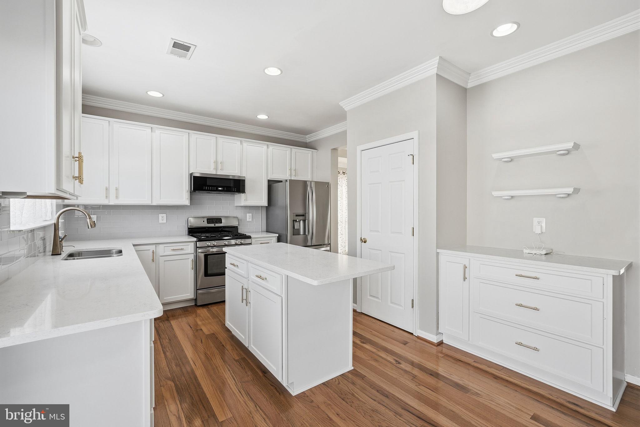 6800 Innesfree Way Gainesville, VA 20155 - Photo 12 of 32 a kitchen with white cabinets and stainless steel appliances