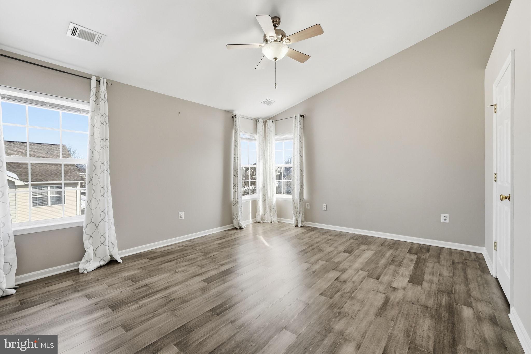 6800 Innesfree Way Gainesville, VA 20155 - Photo 24 of 32 an empty room with wooden floor and windows