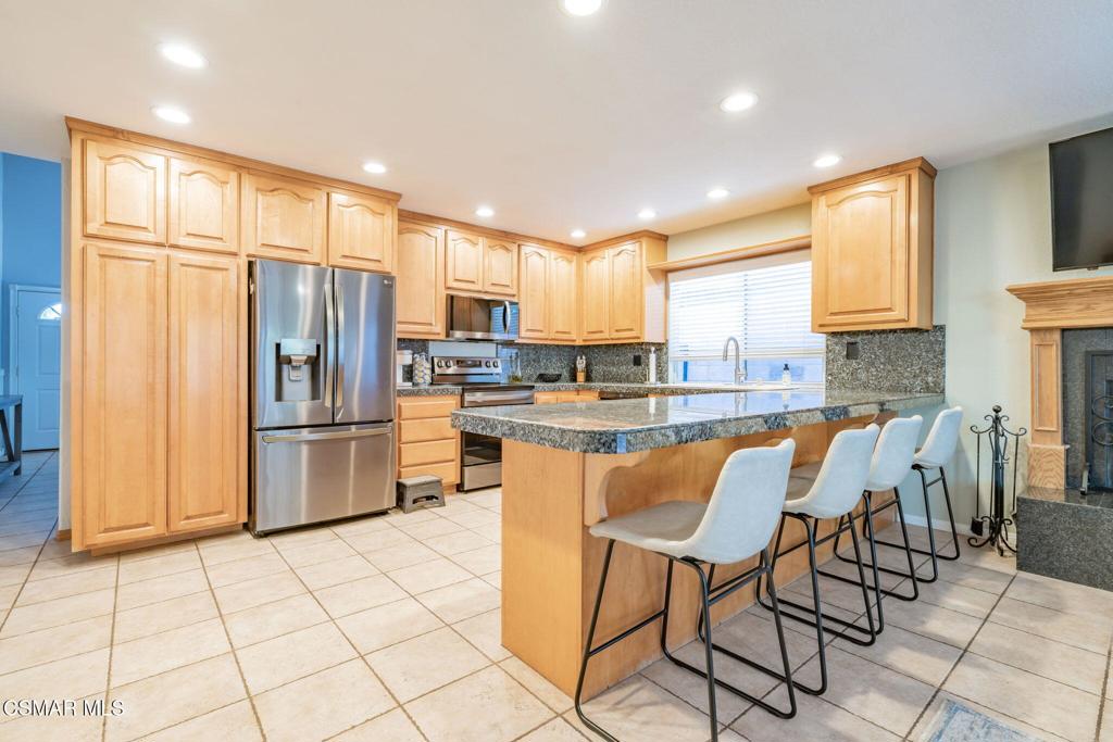 1816 Hillary Court Simi Valley, CA 93065 - Photo 15 of 58 a kitchen with stainless steel appliances a refrigerator a stove a sink cabinets and a dining table