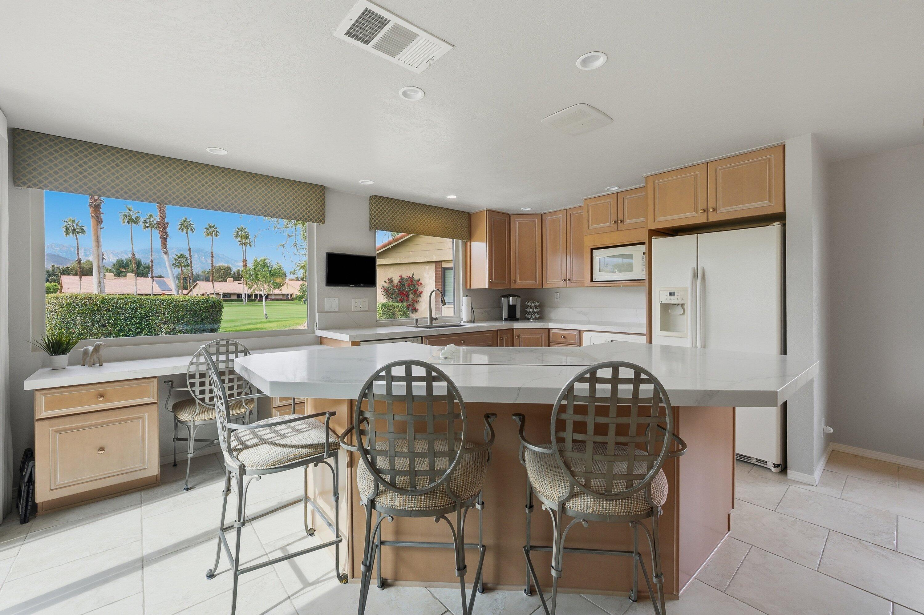 19 Maximo Way Palm Desert, CA 92260 - Photo 9 of 20 a kitchen with stainless steel appliances a table chairs refrigerator and cabinets