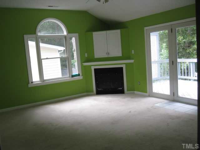 2813 Old Orchard Road Raleigh, NC 27607 - Photo 6 of 11 an empty room with windows and fireplace