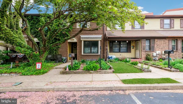 a front view of a house with a yard and a garden
