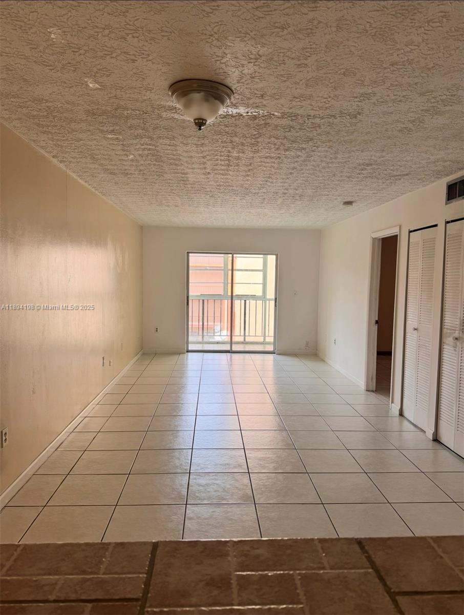 6055 West 19th Avenue, Unit 304 Hialeah, FL 33012 - Photo 11 of 24 a view of an empty room and a window