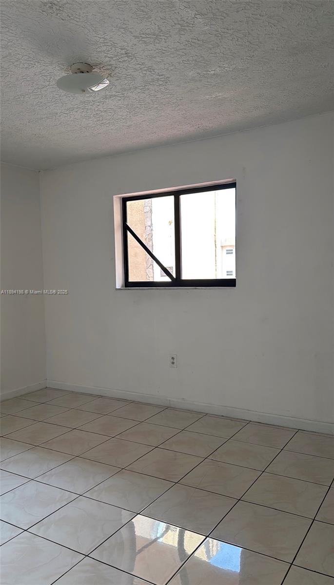 6055 West 19th Avenue, Unit 304 Hialeah, FL 33012 - Photo 20 of 24 an empty room with a window