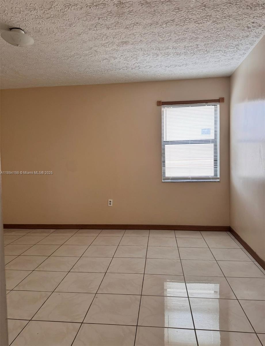 6055 West 19th Avenue, Unit 304 Hialeah, FL 33012 - Photo 22 of 24 a view of an empty room with a window