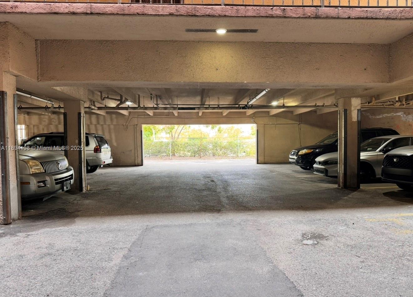 6055 West 19th Avenue, Unit 304 Hialeah, FL 33012 - Photo 7 of 24 a view of parking garage with cars
