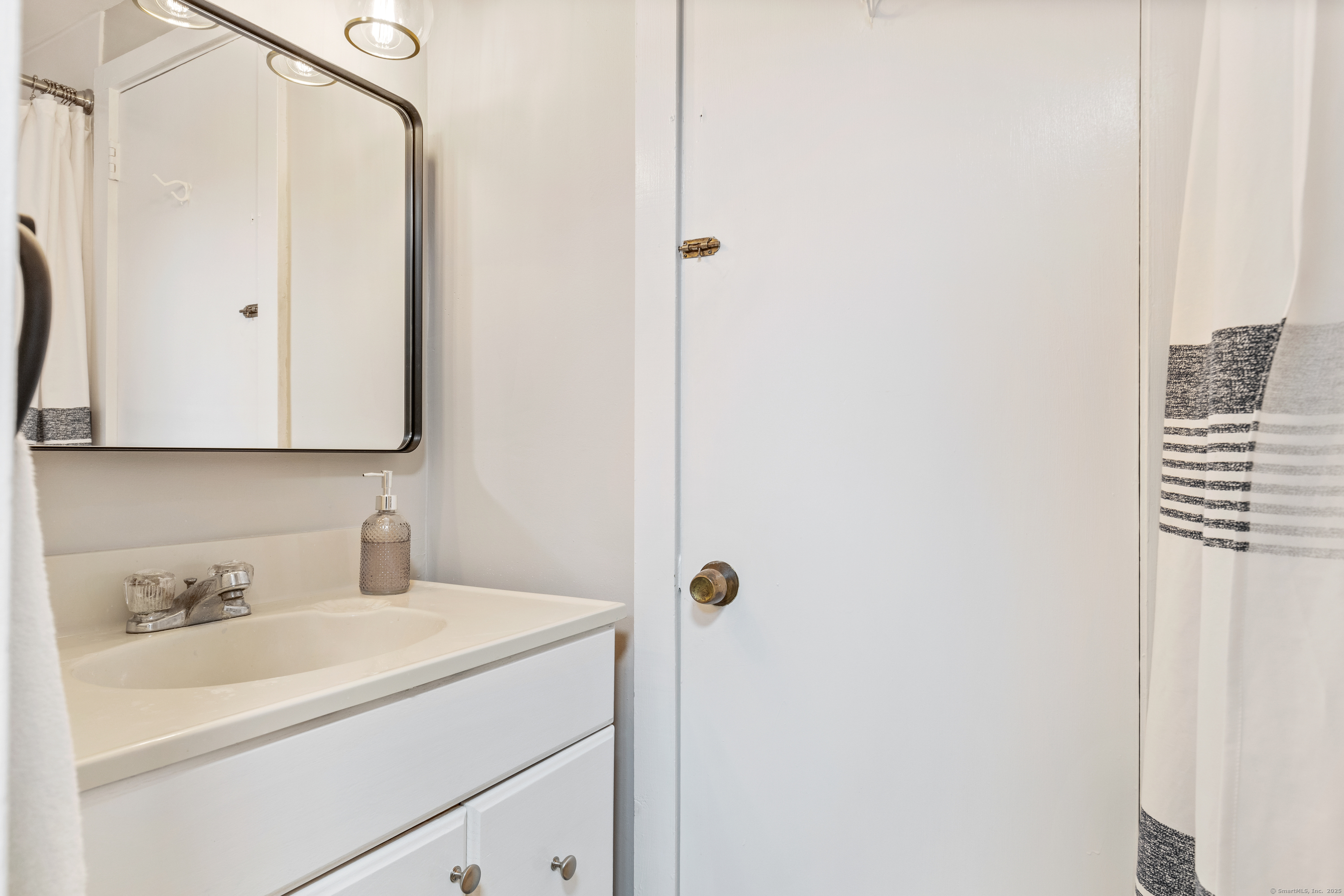 176 Shore Road Clinton, CT 06413 - Photo 39 of 40 a bathroom with a sink and a mirror