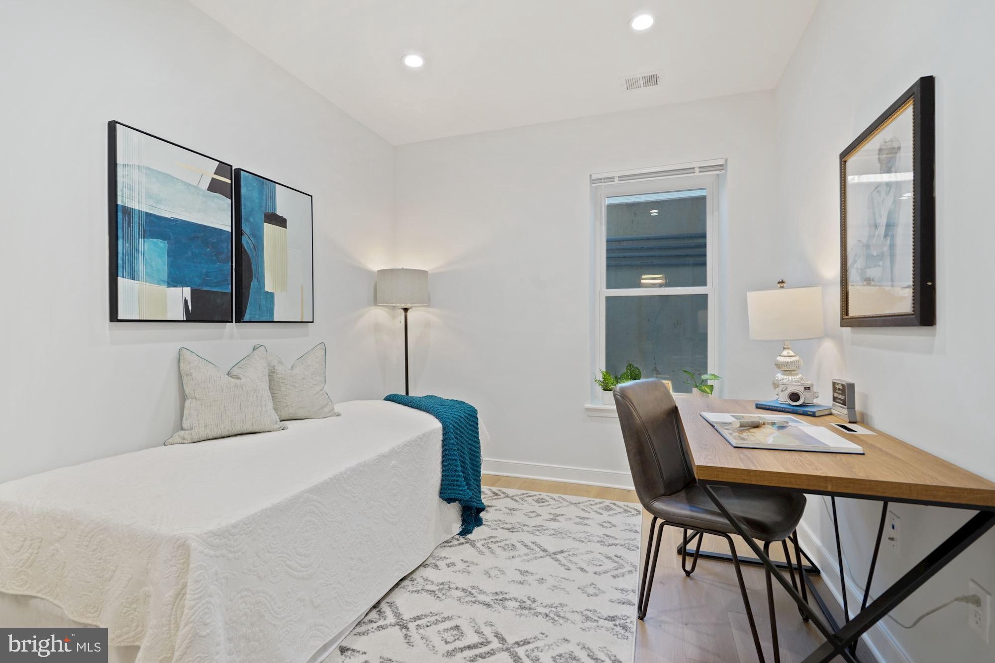 1021 Spring Road Northwest, Unit 1 Washington, DC 20010 - Photo 14 of 27 a bedroom with a bed and a table in it