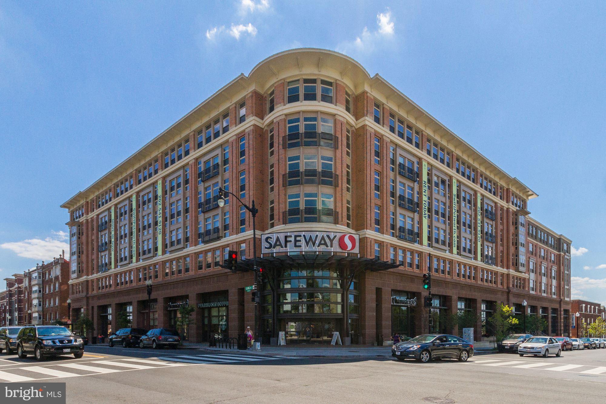 1021 Spring Road Northwest, Unit 1 Washington, DC 20010 - Photo 23 of 27 a front view of multi story building with retail shops car parked and traffic signal
