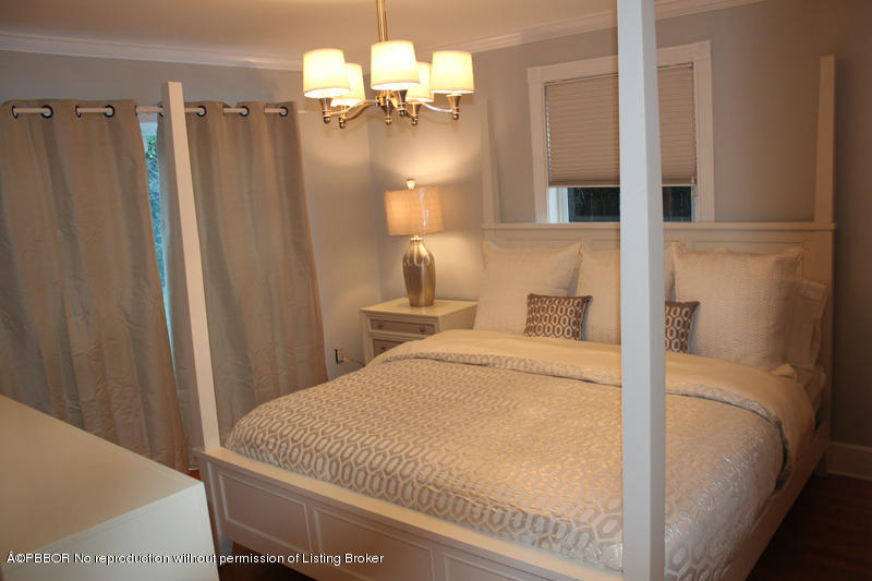 825 Sunset Road West Palm Beach, FL 33401 - Photo 4 of 12 a bedroom with a bed and a chandelier