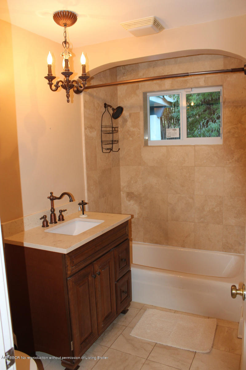 825 Sunset Road West Palm Beach, FL 33401 - Photo 6 of 12 a bathroom with a sink a mirror and a bathtub