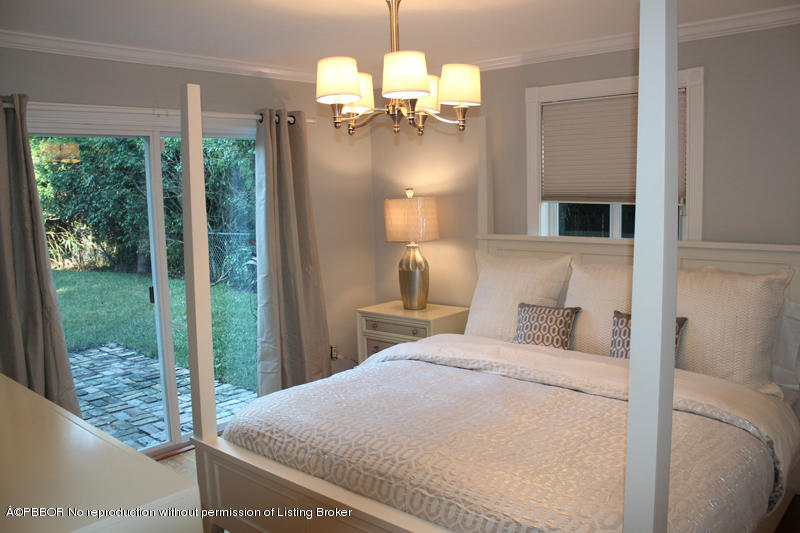825 Sunset Road West Palm Beach, FL 33401 - Photo 7 of 12 a bedroom with a large bed and a chandelier
