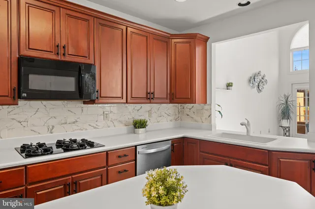 a kitchen with stainless steel appliances granite countertop a sink stove and microwave