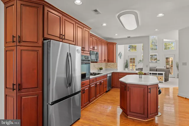 a kitchen with stainless steel appliances granite countertop a refrigerator a sink and dishwasher