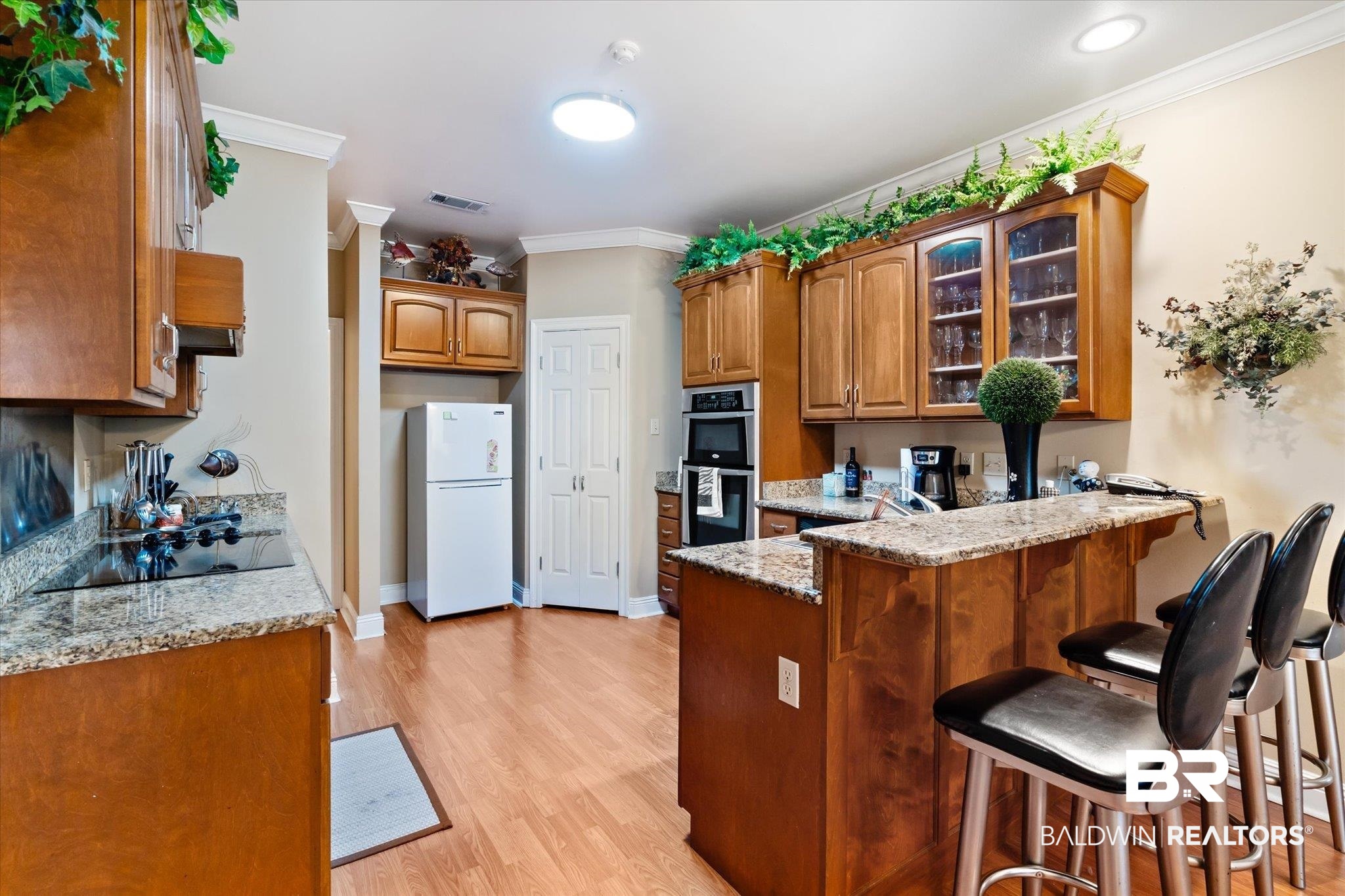 2400 Waterford Road Semmes, AL 36575 - Photo 11 of 30 Kitchen featuring freestanding refrigerator, black electric stovetop, a peninsula, stainless steel double oven, and ornamental molding
