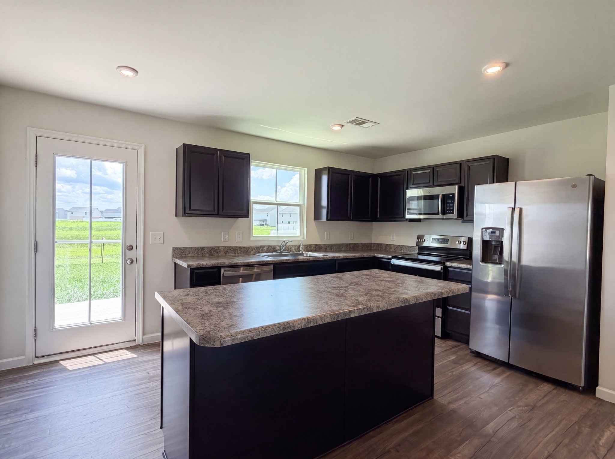937 Blue Ash Way Christiana, TN 37037 - Photo 6 of 22 a large kitchen with a stove a sink dishwasher a refrigerator and a microwave oven with wooden floor