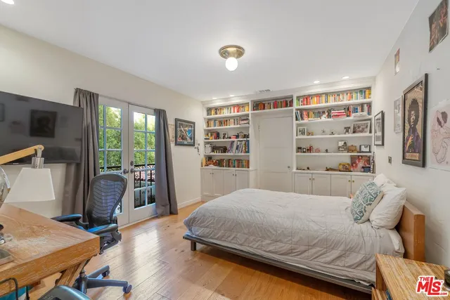a bedroom with a large bed and a flat tv screen
