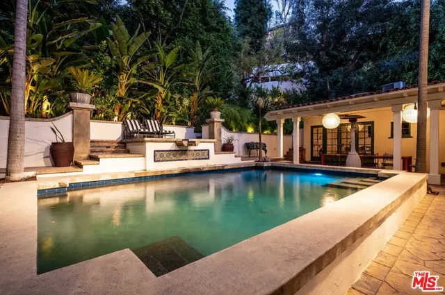 a view of a lake with a house and swimming pool