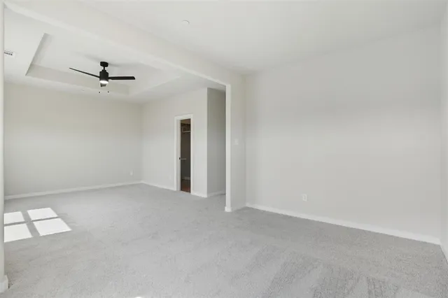 an empty room with a ceiling fan and a window