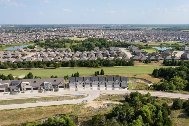 an aerial view of a house with a garden and lake view